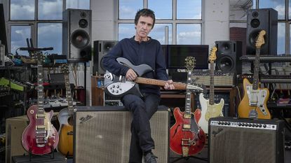 A photo of Johnny Marr holding a guitar. 