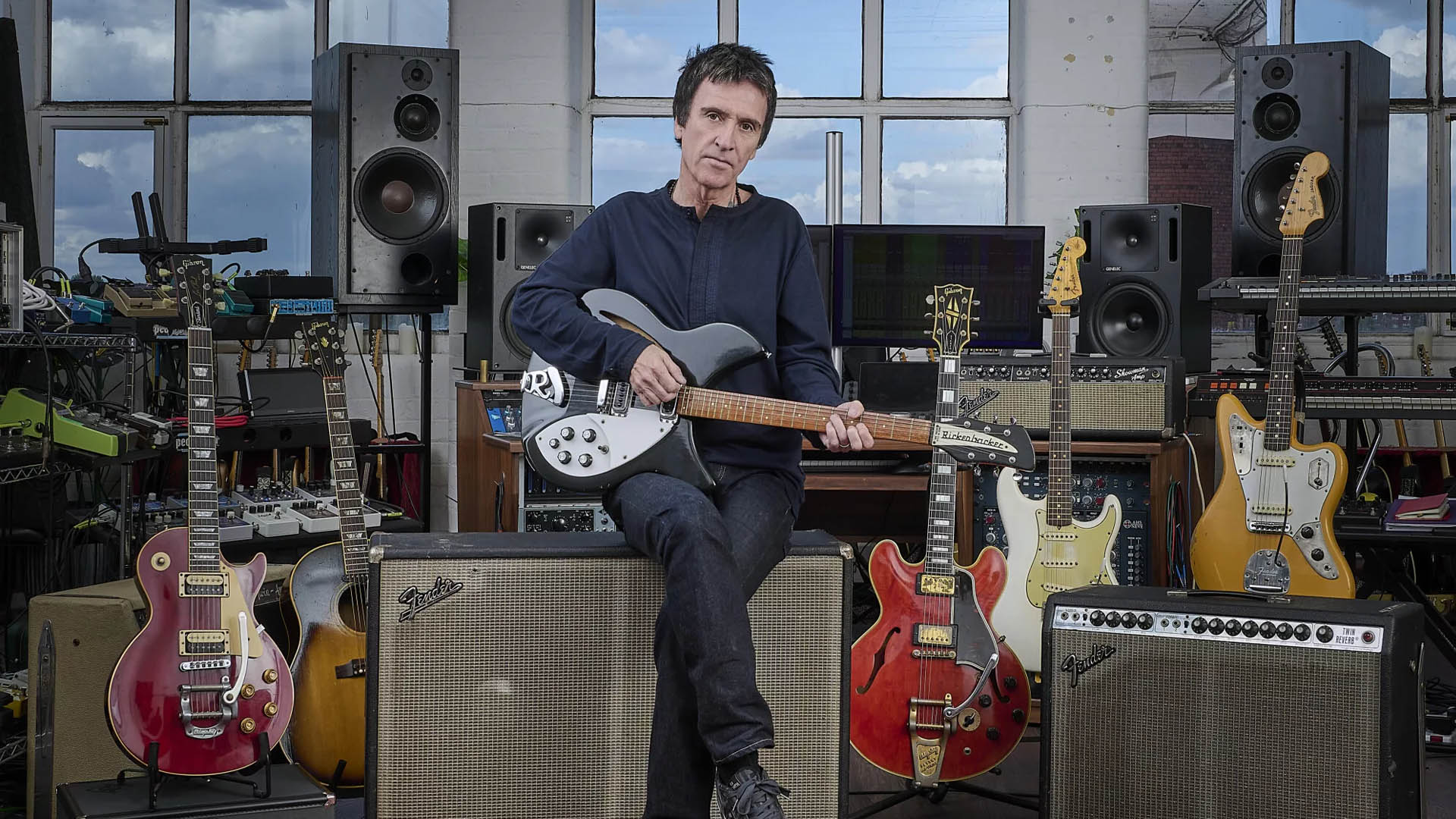 A photo of Johnny Marr holding a guitar. 