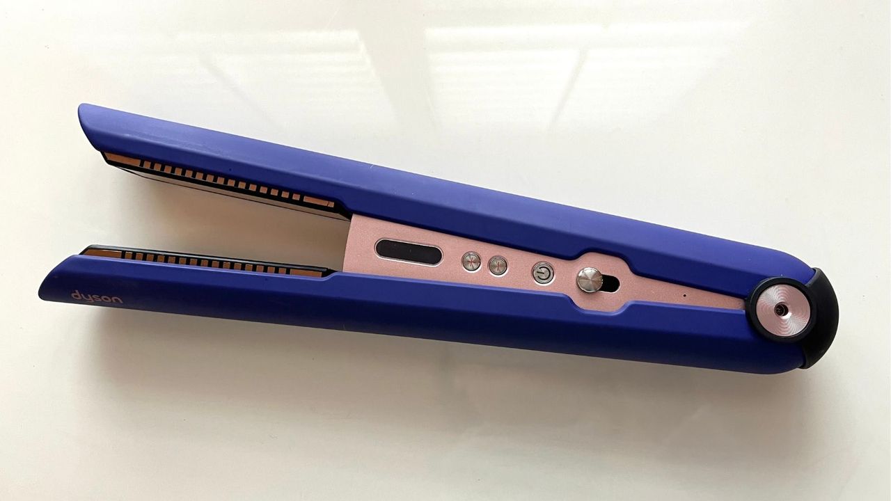 Photo of the purple and pink Dyson Corrale cordless hair straighteners on a white tabletop