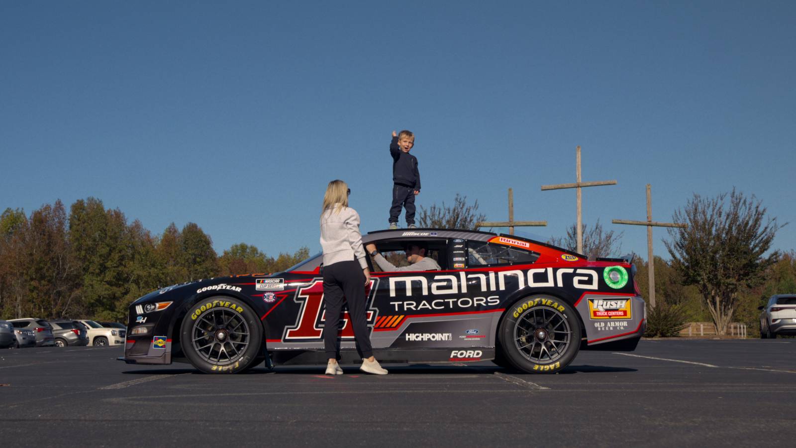A child standing on a NASCAR vehicle in Full Speed season 2 on Netflix.