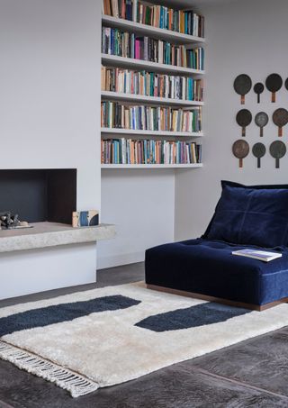 living room with book shelf blue armchair