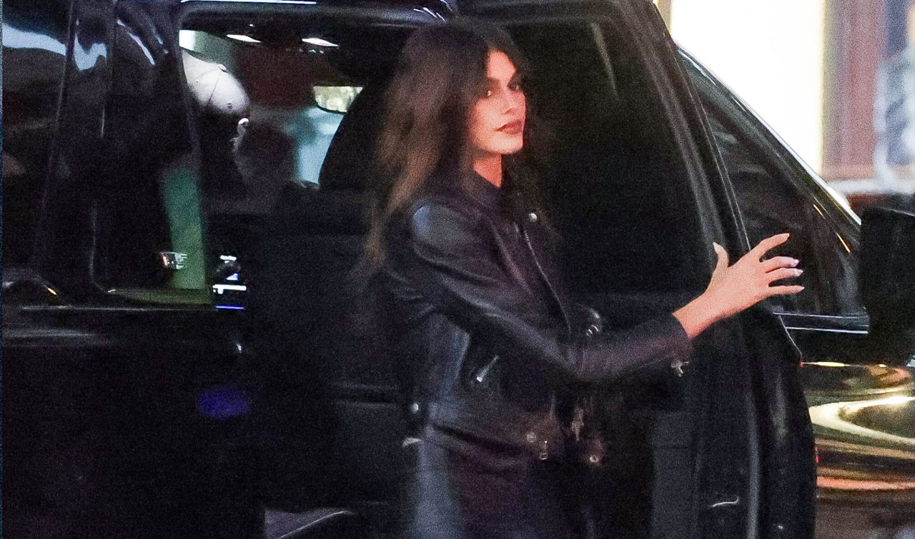 Kaia Gerber gets out of a car in New York City wearing a leather jacket and a mini skirt with moto boots