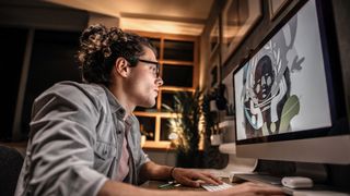 A man using a computer to create digital art work