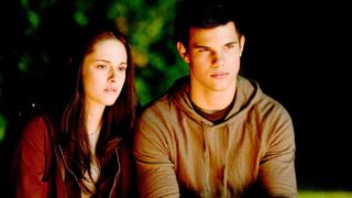 In a still from the Twilight movie, Jacob and Bella sit together at night.