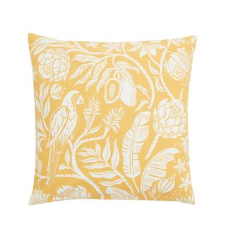 Yellow throw pillow with white florals and parrots 