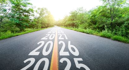 years 2025 2026 2027 and beyond painted on a roadway flowing into a tree line