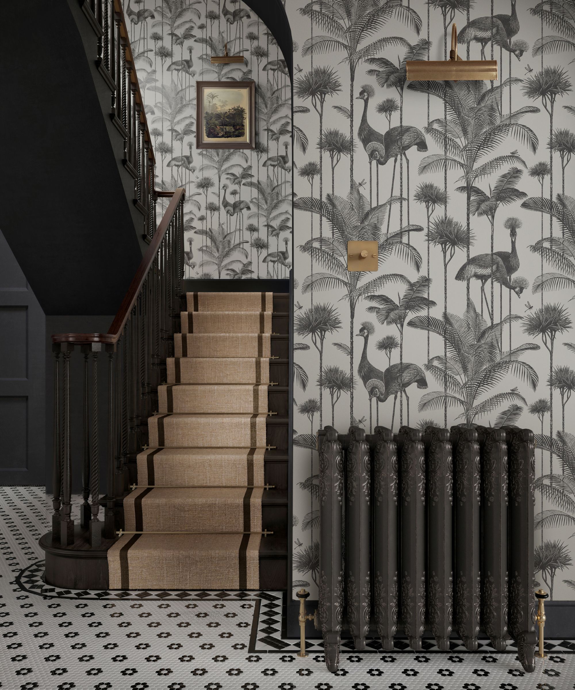 A hallway with monochrome wallpaper of cranes and palm trees. The dark wood staircase has a beige runner, and a black ornate radiator stands against patterned black-and-white tiled flooring.
