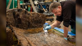 Ian Panter, head of conservation at York Archaeological Trust, helps preserve the wooden coffin.