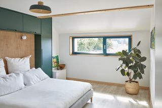 white bedroom with blue windows and timber cladding