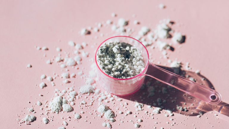 Wellness, fitness, exercise, protein powder, Measuring spoon with collagen powder or alginate mask on pink background, dry scooping tiktok