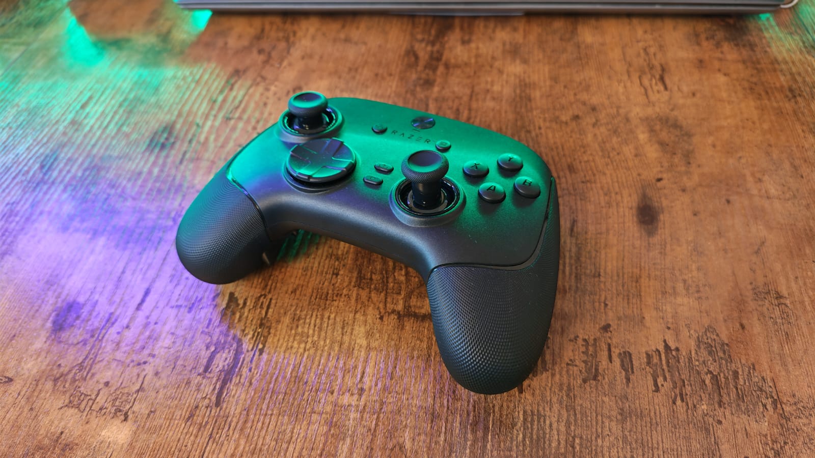 The Razer Wolverine V3 Pro 8K lying under green lighting