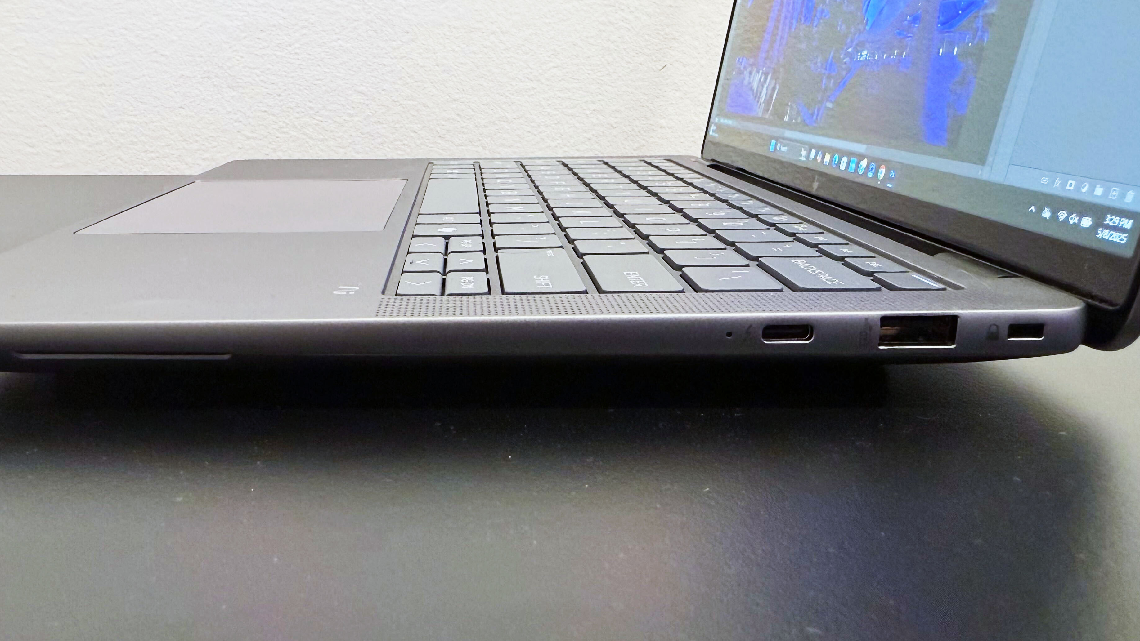 Close-up of the right-side ports on the HP ZBook Ultra 14 G1a mobile workstation open on a black desk against a white wall.