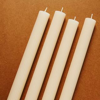 Fluted Taper Candles against a brown background.