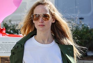 Jennifer Lawrence spotted in Los Angeles wearing a green jacket, white tee, and long denim skirt.