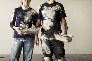 diy tips: a woman and man covered in paint during diy