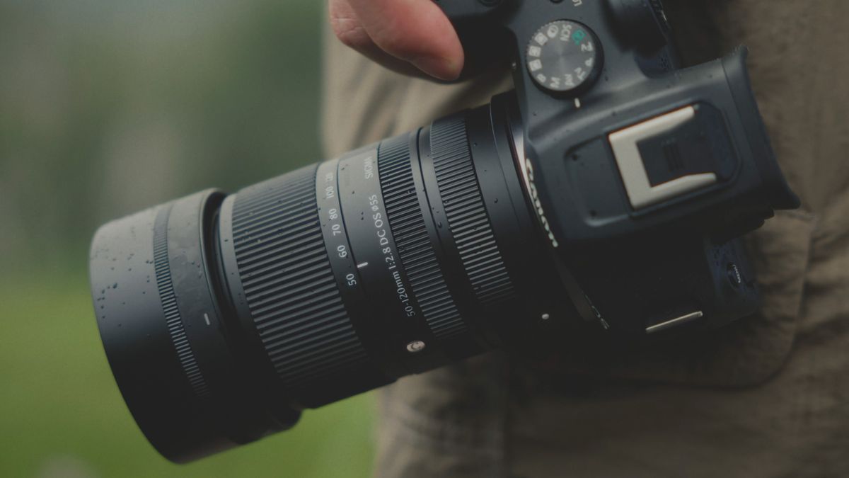 Sigma 50-120mm F2.8 DC OS Contemporary lens attached to a Canon camera, held by a photographer outdoors