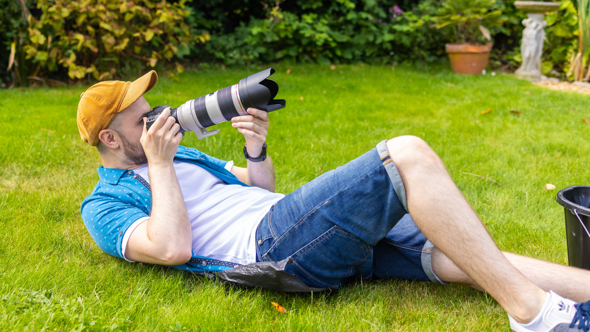 A man laying on his back to get a low angle with his camera and 70-200mm lens