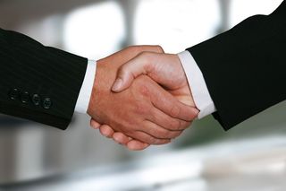 Close up of two hands locked in a firm handshake.