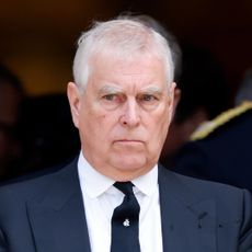 Prince Andrew wearing a suit and scowling