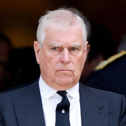 Prince Andrew wearing a suit and scowling