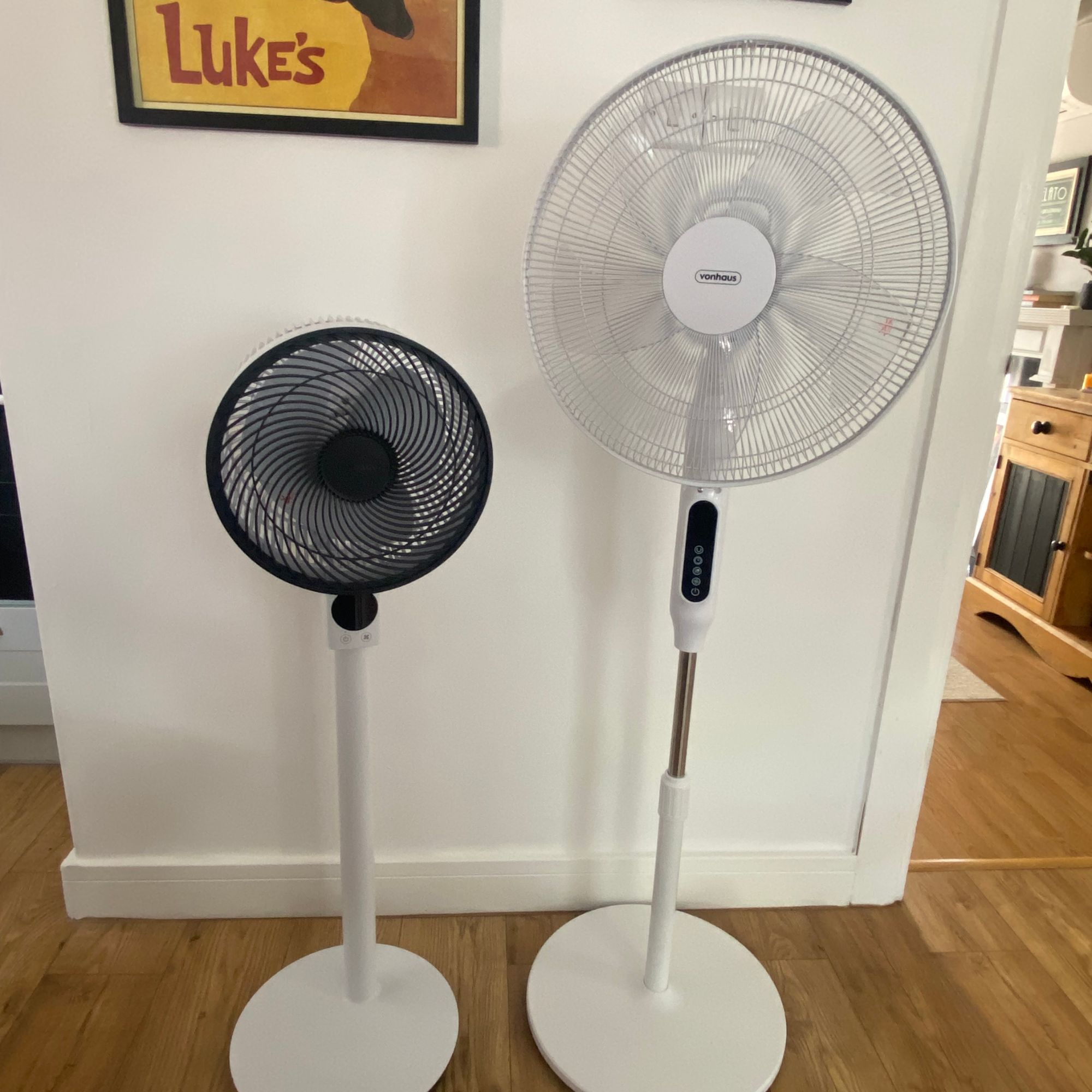The Meaco Sefte pedestal air circulator and the Vonhaus 16'' pedestal fan side by side in my kitchen diner in front of a white wall and on a wood-look floor