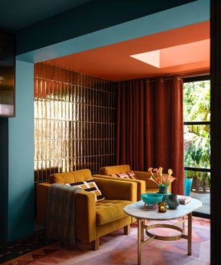 living room with red tiled wall, red ceiling, blue entryway and mustard yellow armchairs