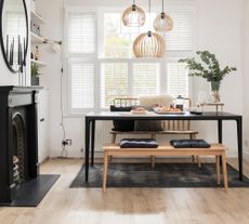 White dining room with black dining table and wood floor