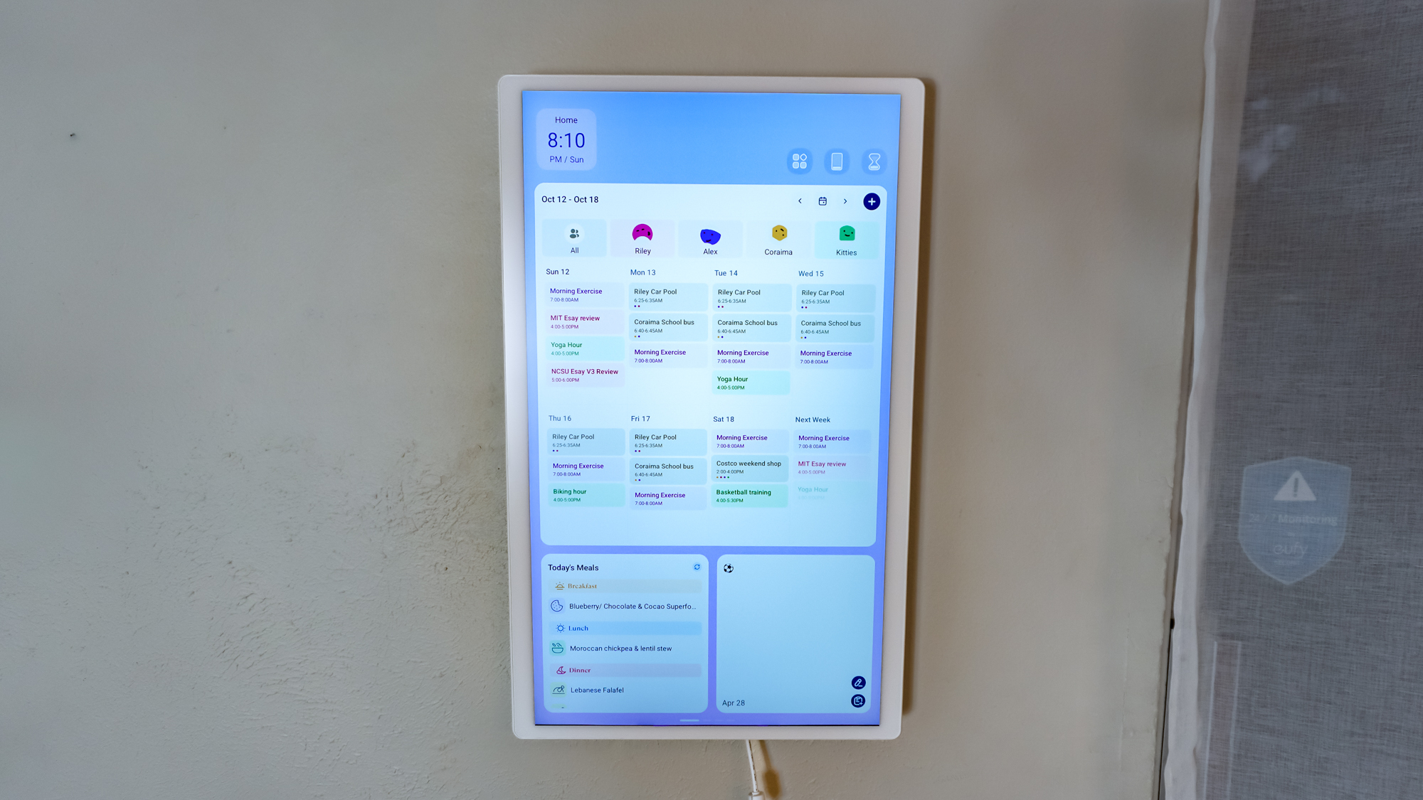 The Cozyla Calendar 2+ mounted on a wall with its power cord hanging down from the bottom
