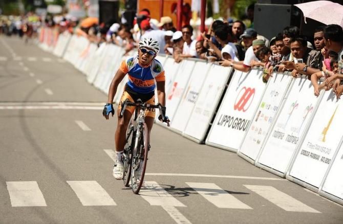 Jamalidin Novardianto winced in pain after reaching the finish line at Stage 6. He was transported by ambulance to the hospital for broken bones in the hand due to the crash 100m from the stage finish