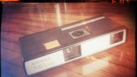An old retro 100 camera on a table