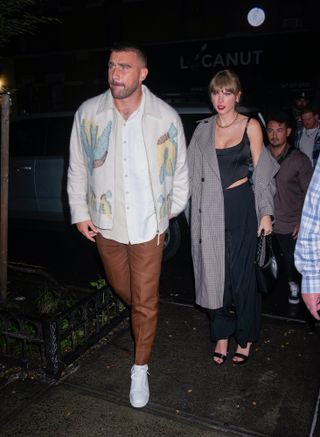 Taylor Swift and Travis Kelce on their first public date where Taylor Swift wears a black Versace corset