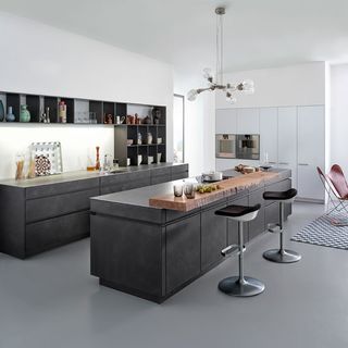kitchen room with dark grey counter with metal chairs