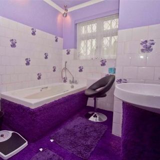 bathroom with purple carpet floor and white wall tiles with bathtub