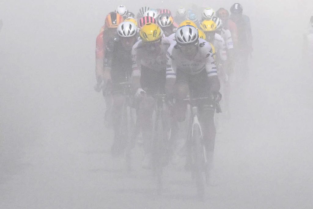 The pack of riders (peloton) kicks up dust as they cycle over a "Chemin Blanc" (white road) gravel sector during the 9th stage of the 111th edition of the Tour de France cycling race, 199km stage departing and finishing in Troyes, on July 7, 2024. (Photo by Bernard PAPON / POOL / AFP)
