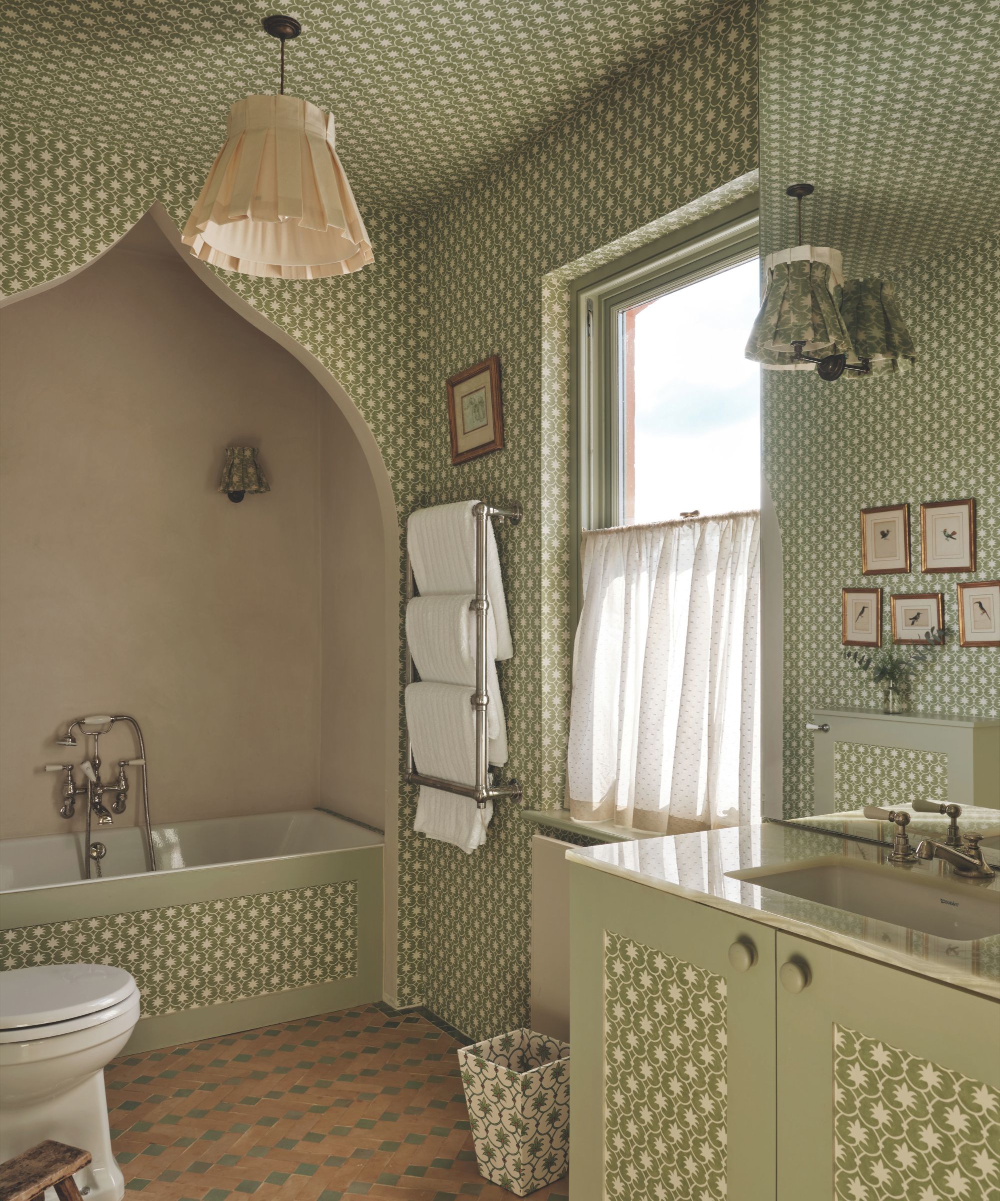 A green and white polka dot bathroom with a framed bath area