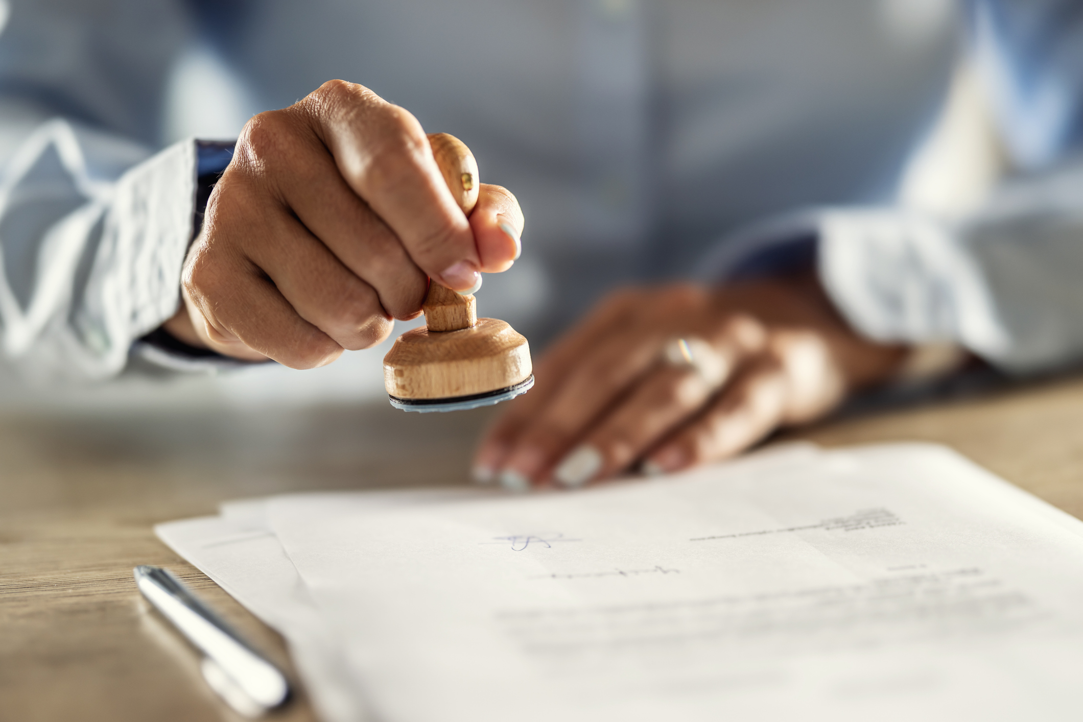 A notary office assistant stamps a document. 