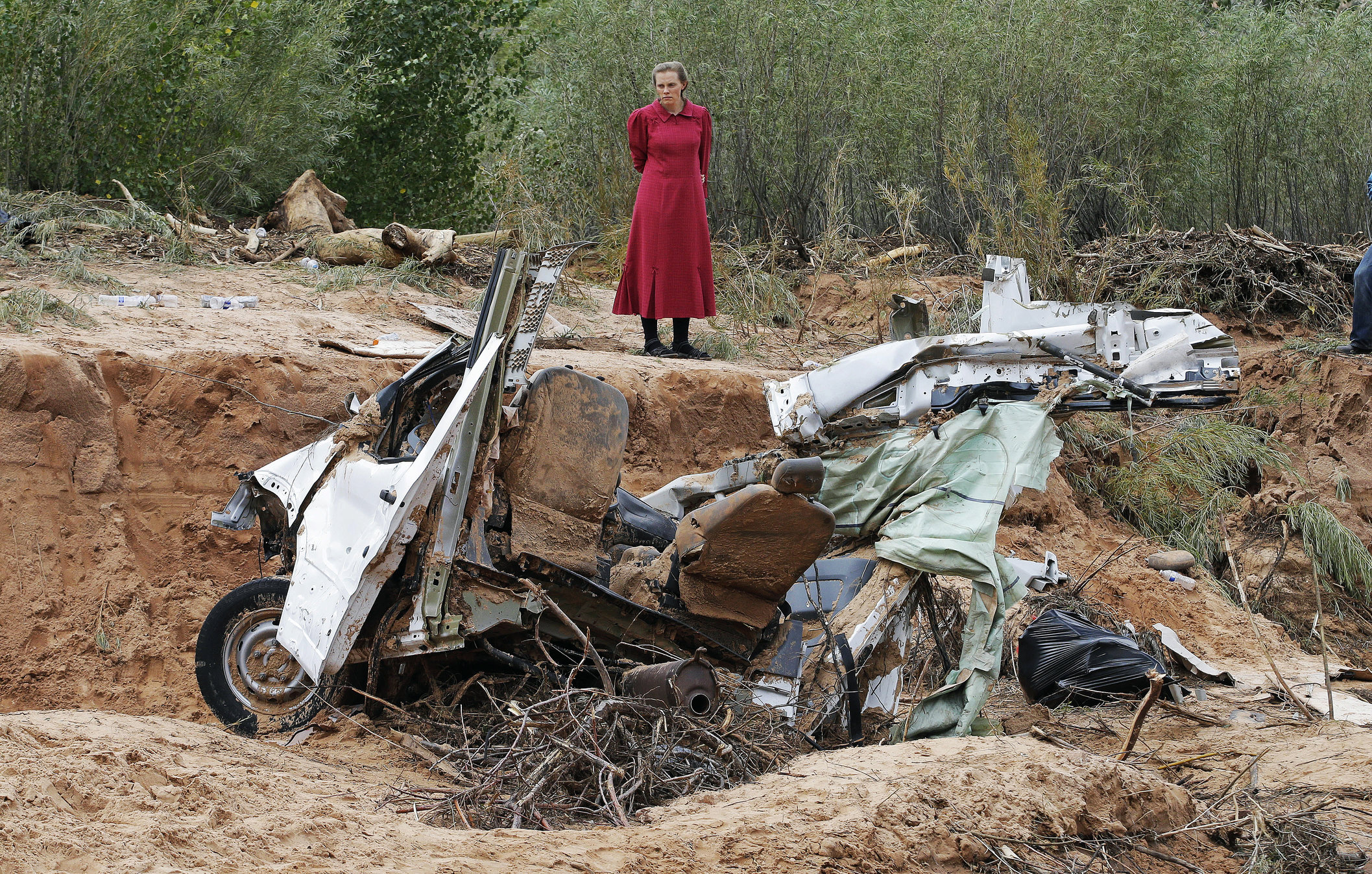 A woman looks at a vehicle swept away during a flash flood in Hildale, Utah.