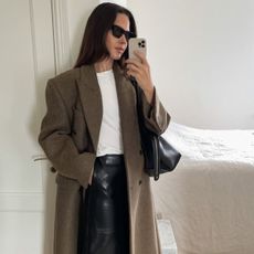 Content creator Johanna Pispa wearing a brown coat, leather skirt and white t shirt.
