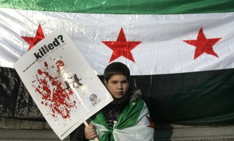 A boy attends a London demonstration against Syrian President Bashar al-Assad: Opposition forces say 9,000 Syrians have been killed during Assad&amp;#039;s lethal assault on pro-democracy activists.