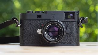 Leica M11-P on wooden table with 50mm f/2 lens attached