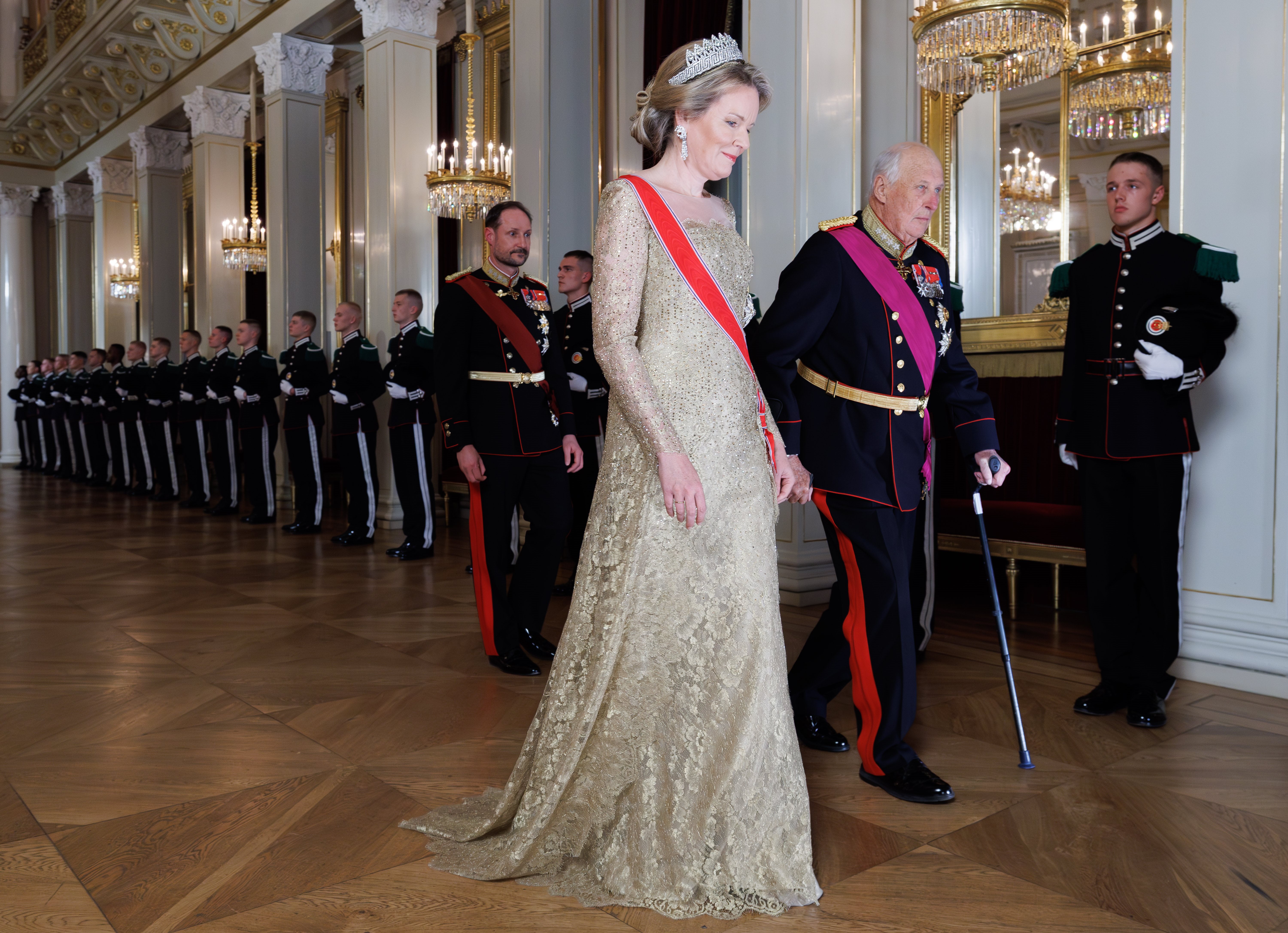 Queen Mathilde wearing a gold gown and diamond tiara
