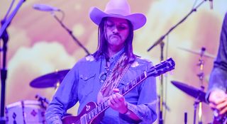 Duane Betts wears a western shirt and cowboy hat as he plays his Gibson Les Paul Standard onstage during the during the Allman Betts Family Revival at Nashville's Ryman Auditorium.