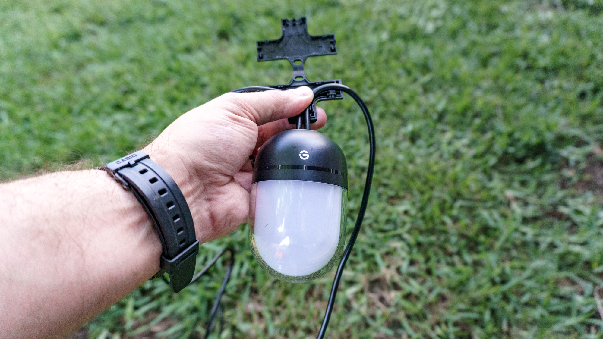 A person installing Govee's Outdoor Chromatic String Lights