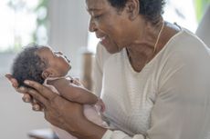 A grandmother looks into the eyes of her infant granddaughter.