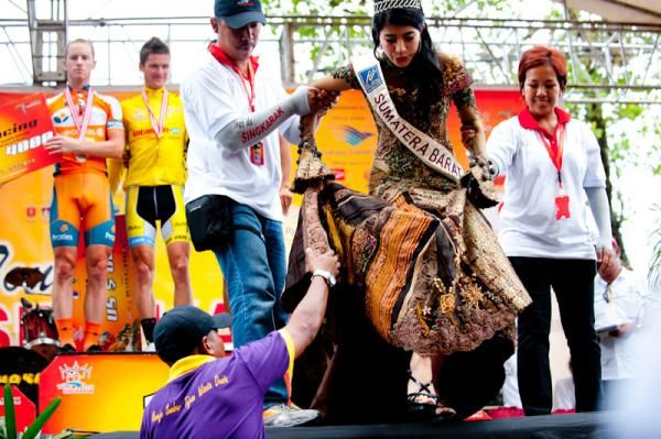 A lady in a traditional dress steps off the podium