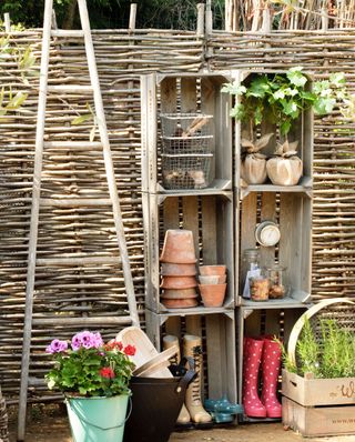 garden screen with willow panel and ladder with shoes on shelf
