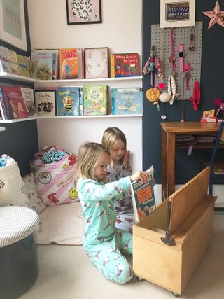 Reading corner in a child's room with storage by Blue Ticking