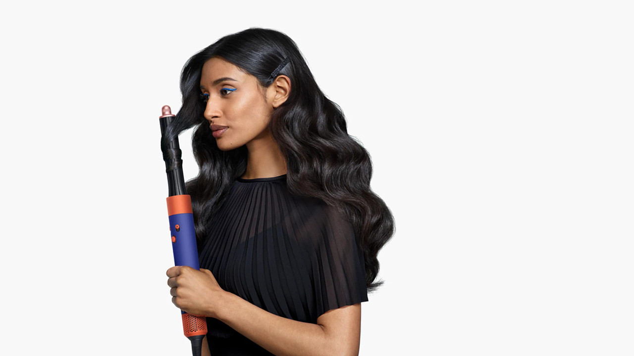 Woman using Dyson's Airwrap i.d. with its barrel attachment