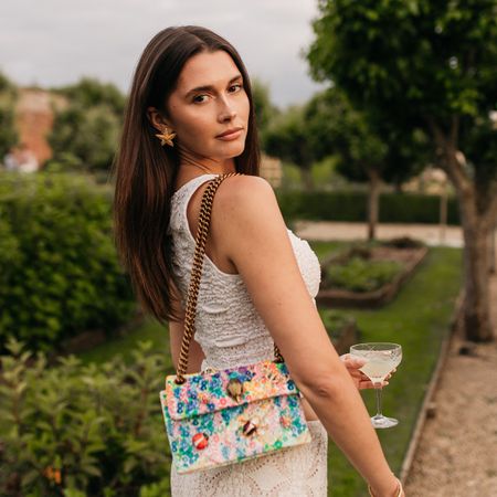 Woman wearing Kurt Geiger Floral Couture collection Kensington handbag.