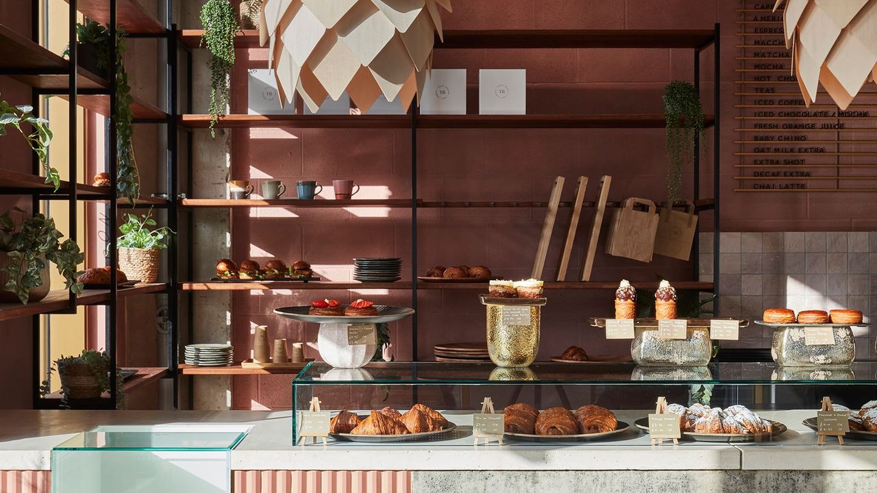 The rose-hued interiors of a bakery, lit up by sunshine.